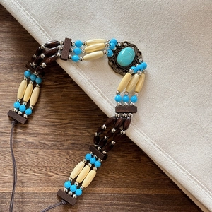 Detailed macro view of Bohemian multilayer turquoise and wood bead necklace on wood table