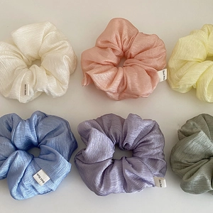 Set of six pastel textured fabric scrunchies with Hand Made labels on white background