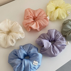 Set of six pastel scrunchies with pleated texture and Hand Made label on white background