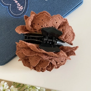 Détail de la dentelle brodée marron caramel sur une pince à cheveux de style rétro
