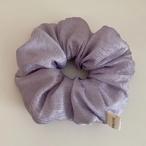 Detail of lavender scrunchie with pleated texture and white Hand Made label