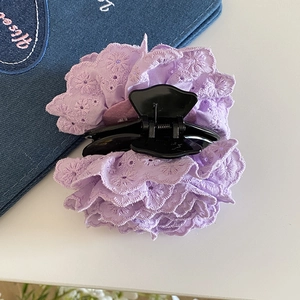 Détail d'une pince à cheveux rose en dentelle violet clair avec broderie florale délicate