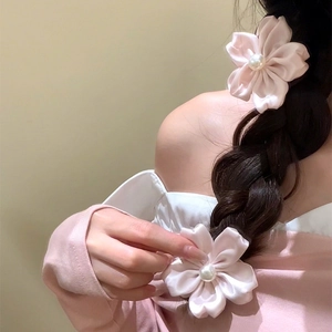 Romantische rosa Kirschblüten-Haargummis mit Satinblüten und Perlen auf dunklem Zopf