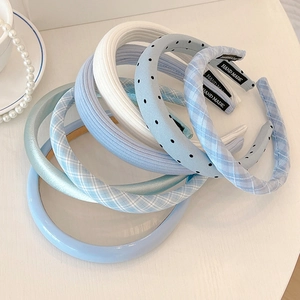 Blue and white polka dot headbands with handmade tags shown in a stylish collection
