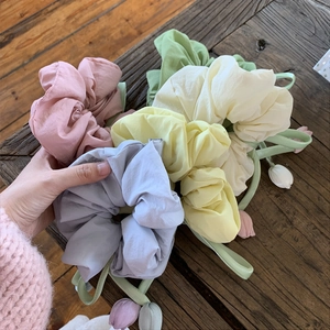Floral tulip scrunchie set with pastel fabric flower charms on rustic wood background
