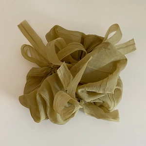 Détail d'un chouchou en organza vert olive montrant la texture plissée fine et légère