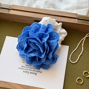 Detail of blue floral embroidery hair scrunchie with intricate hollow pattern textures
