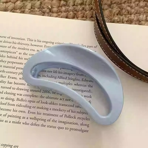 Vue détaillée d'une pince à cheveux minimaliste bleu clair sur un livre ouvert