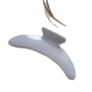 Pince à cheveux minimaliste bleu clair en forme de croissant avec une finition brillante