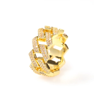 Détail macro d'une bague maille cubaine dorée ornée de zircons scintillants de style hip-hop