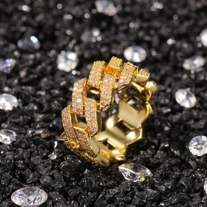 Gros plan d'une bague à maillons cubains sertie de zircons sur fond minéral noir