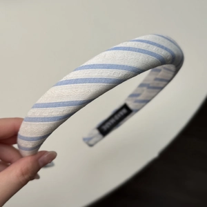 Détail du serre-tête en tissu rayé bleu avec étiquette de fabrication artisanale