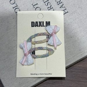 Détail de deux barrettes à rayures violettes avec dentelle sur une carte support