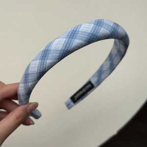 Gros plan du serre-tête à carreaux bleus avec étiquette faite main et texture fine