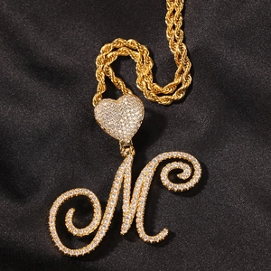 Macro shot of hip hop style heart pendant with M letter and twisted gold rope chain