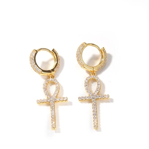 Détail de créoles croix Ankh dorées avec cristaux pavés et finition métal poli
