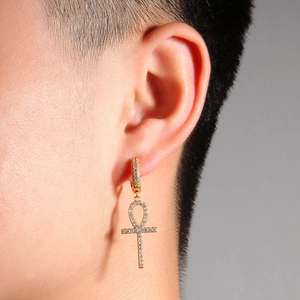 Détail d'une boucle d'oreille croix Ankh hip-hop plaquée or avec zircons blancs