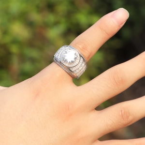 Dettaglio macro dell'anello hip hop da uomo con zirconi pavé e pietra centrale