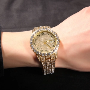 Detailed close-up of a gold quartz watch with rhinestones and Arabic numeral dial