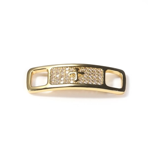 Detail showing gold cross shoe buckle decoration with micro-pave zirconia stones