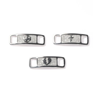 Close-up of hip-hop shoe charms with zircon smiley face, cross, and broken heart