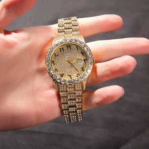 Detail of gold quartz watch featuring full diamond setting and Arabic numeral dial