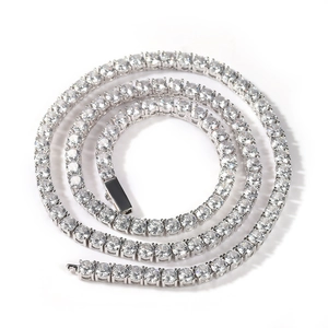 Macro detail of silver tennis necklace with four-claw set round sparkling crystals