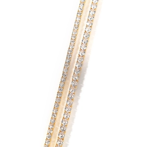 Macro shot of gold tennis chain detail with claw-set round brilliant zircons
