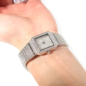 Vue détaillée d'une montre à quartz carrée argentée avec cristaux sur la main