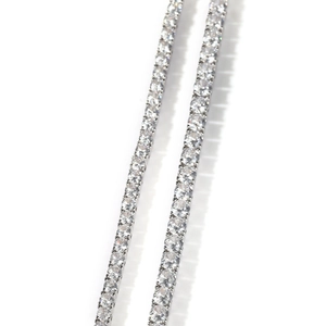 Macro detail showing a single row of sparkling round diamonds on a silver hip hop tennis chain