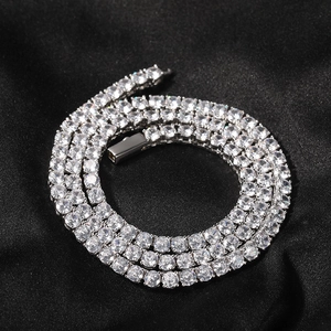 Macro shot of 4mm silver tennis chain with sparkling diamonds on black silk background