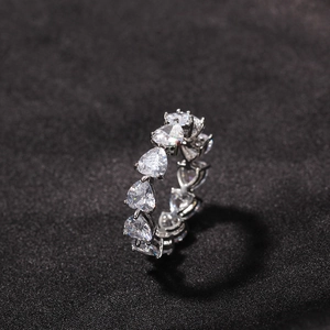 Hip hop style silver eternity ring featuring heart-cut clear zircons in claw setting