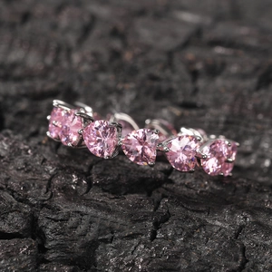 Macro detail of heart-shaped pink cubic zirconia stones in silver claw setting