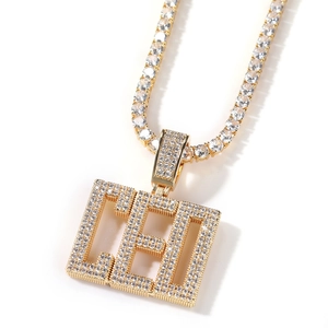 Gros plan du pendentif rectangulaire doré serti de zircons et chaîne tennis