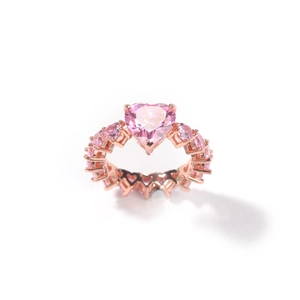 Macro de la bague en or rose avec zircon rose en cœur et anneau serti de cœurs