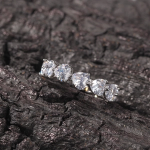 Macro shot of silver ring featuring five heart-shaped zircons with claw settings