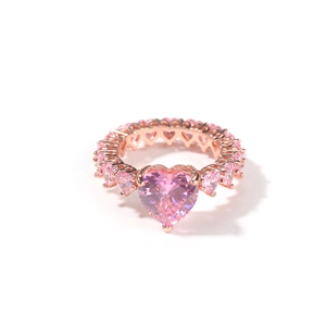 Détail d'une bague en or rose avec un grand zircon cœur rose et des gemmes serties