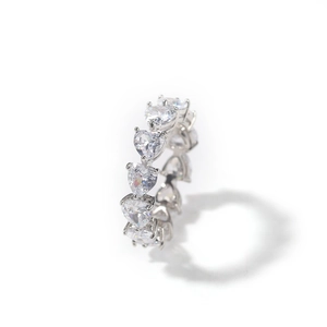 Macro detail of silver hip hop ring featuring heart shaped cubic zirconia stones