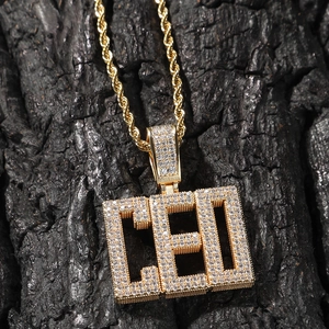 Vue macro d'un collier hip-hop doré avec pendentif lettres CEO orné de zircons scintillants