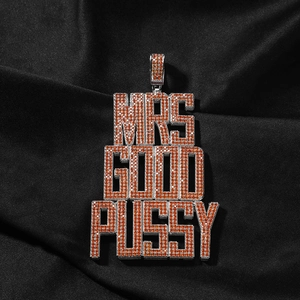 Vue détaillée du pendentif hip-hop avec zircons orange et blancs sur tissu de soie
