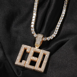 Détail macro du pendentif CEO glacé avec chaîne tennis sur texture de soie noire