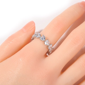 Detailed macro view of heart-cut cubic zirconia row setting on a silver ring band