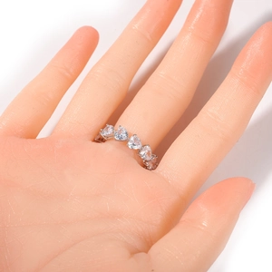 Macro shot of a silver heart-shaped cubic zirconia eternity ring on a model finger