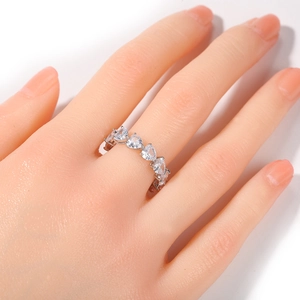 Detail of silver hip hop ring featuring heart-shaped cubic zirconia in claw setting