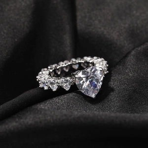 Vue macro d'une bague de luxe en forme de cœur avec pavé de zircons sur soie noire