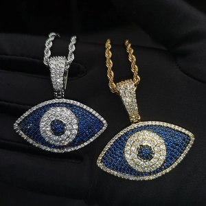 Vue rapprochée de pendentifs œil de démon en or et argent avec strass bleus et chaîne corde