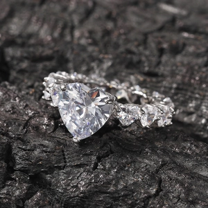 Gros plan d'une bague zircon en forme de cœur sur fond de charbon montrant les détails fins