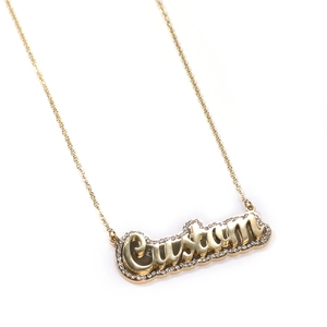 Detail of custom double-layered gold name necklace with sparkling crystal inlay