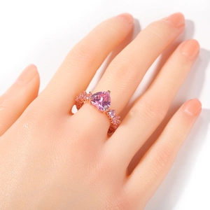 Gros plan d'une bague cœur en or rose avec zircons roses et sertissage pavé fin