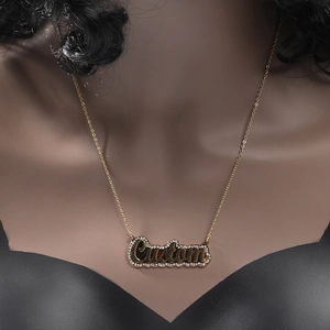 Close-up of a custom gold name necklace with micro-paved rhinestones on a cross chain